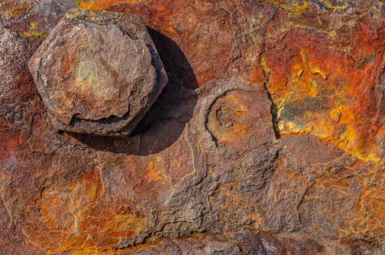 Écrou et plaque de fer couverts d'une rouille orange et feuilletée
